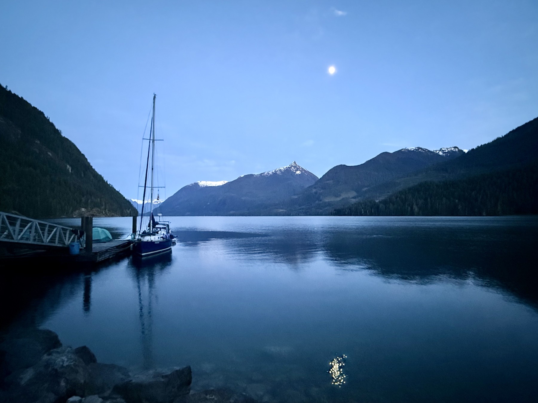 Calm inlet water framed by forested mountains